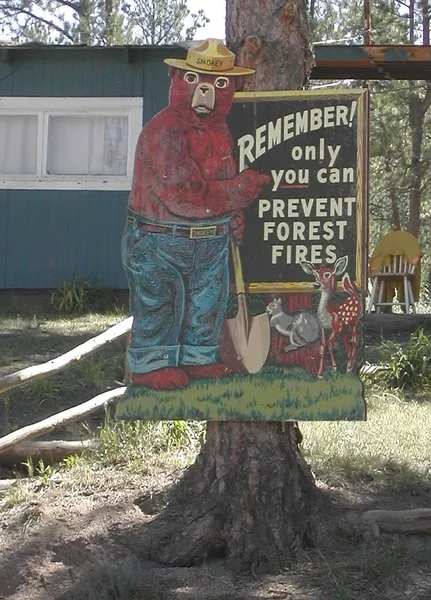 Irony - Circa 2002: Irony at its best. Only a few miles from the fire line stands a sign warning forest users to help prevent forest fires.